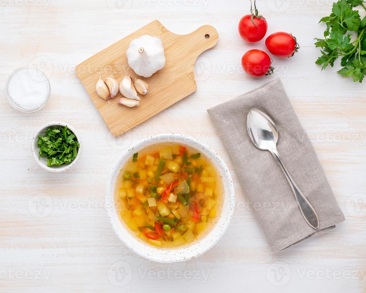 Healthy spring vegetable dietary vegetarian soup, white wooden background, top view, close up photo