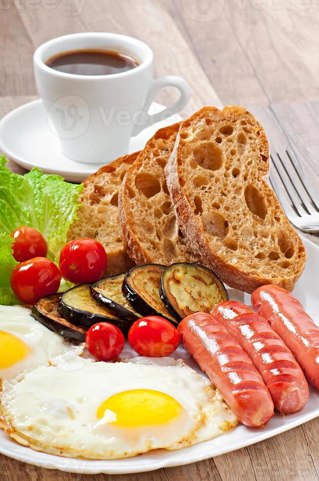 English breakfast - fried eggs, sausages, eggplant and tomatoes photo