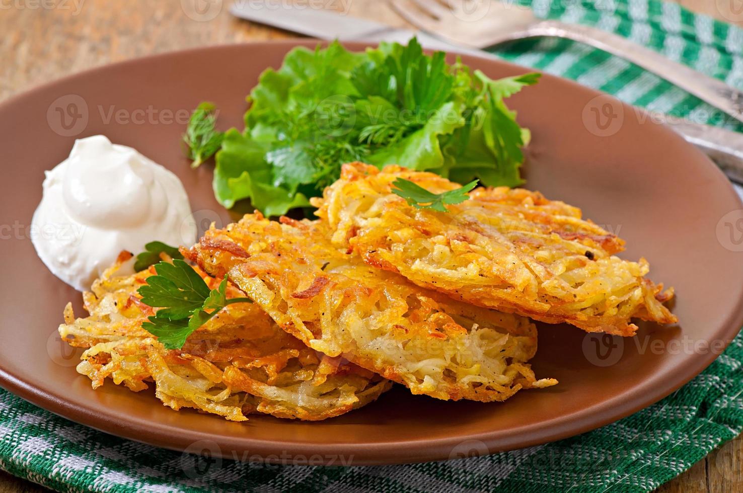 Fragrant potato pancakes with sour cream and herbs photo