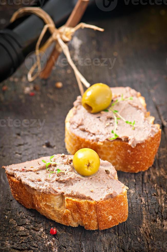 Homemade meat snack chicken liver pate with savory and olives photo