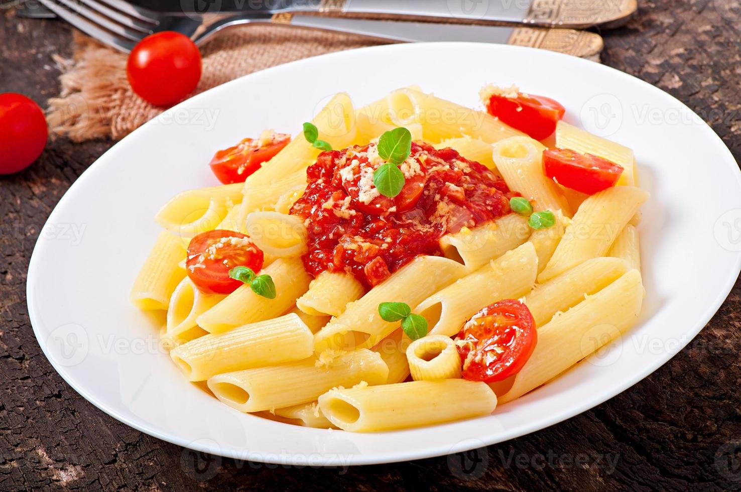 Penne pasta with bolognese sauce, parmesan cheese and basil photo