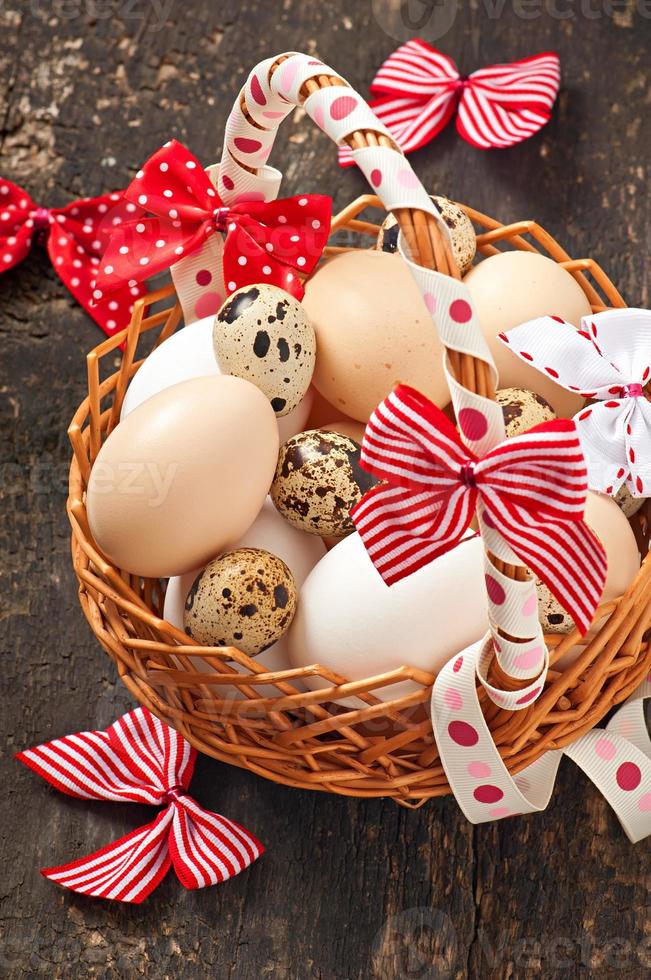 huevos de Pascua y cesta sobre un fondo de madera foto