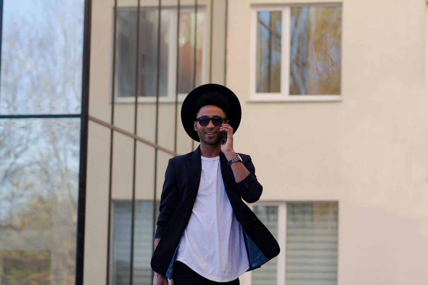 young happy male in black suit and black hat, concept of modern buisinessman photo