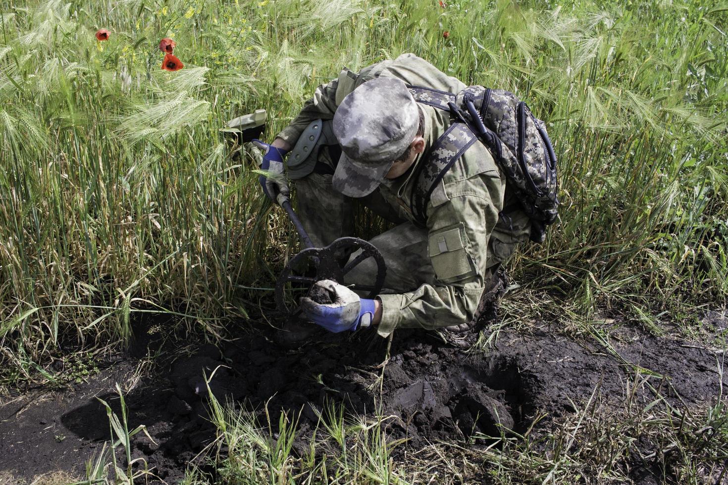 soldado usando un detector de metales en los campos foto