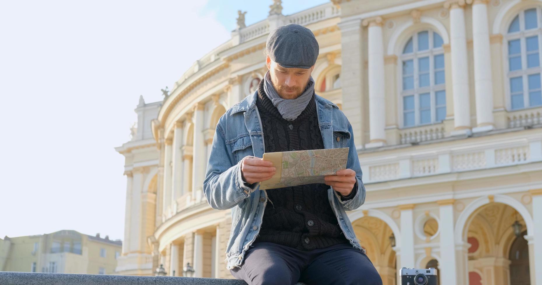Young male traveler with map in the city photo
