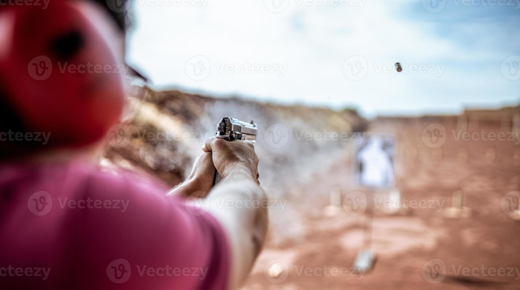 Detail view of shooter holding gun and training tactical shooting, focus on pistol. Shooting range. photo