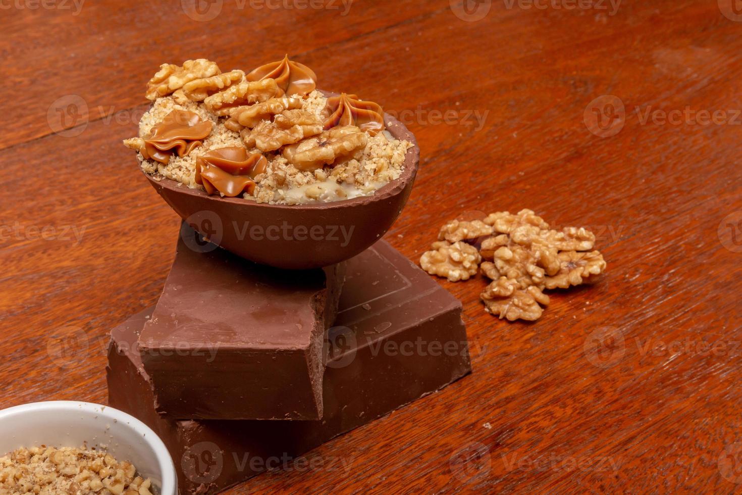 huevo de chocolate relleno de nueces para pascua en el fondo de madera. huevo de pascua casero foto