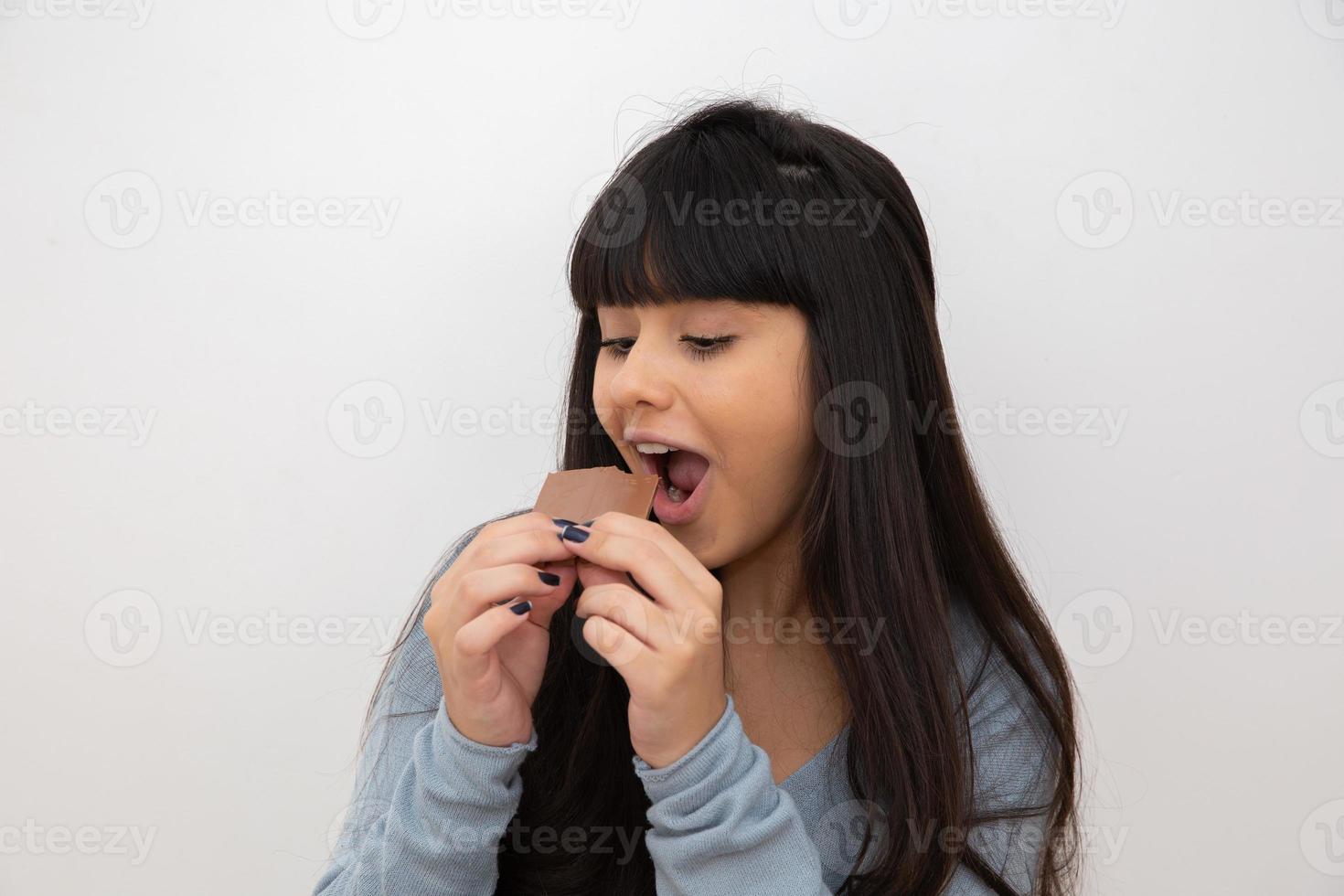 mujer joven comiendo chocolate foto