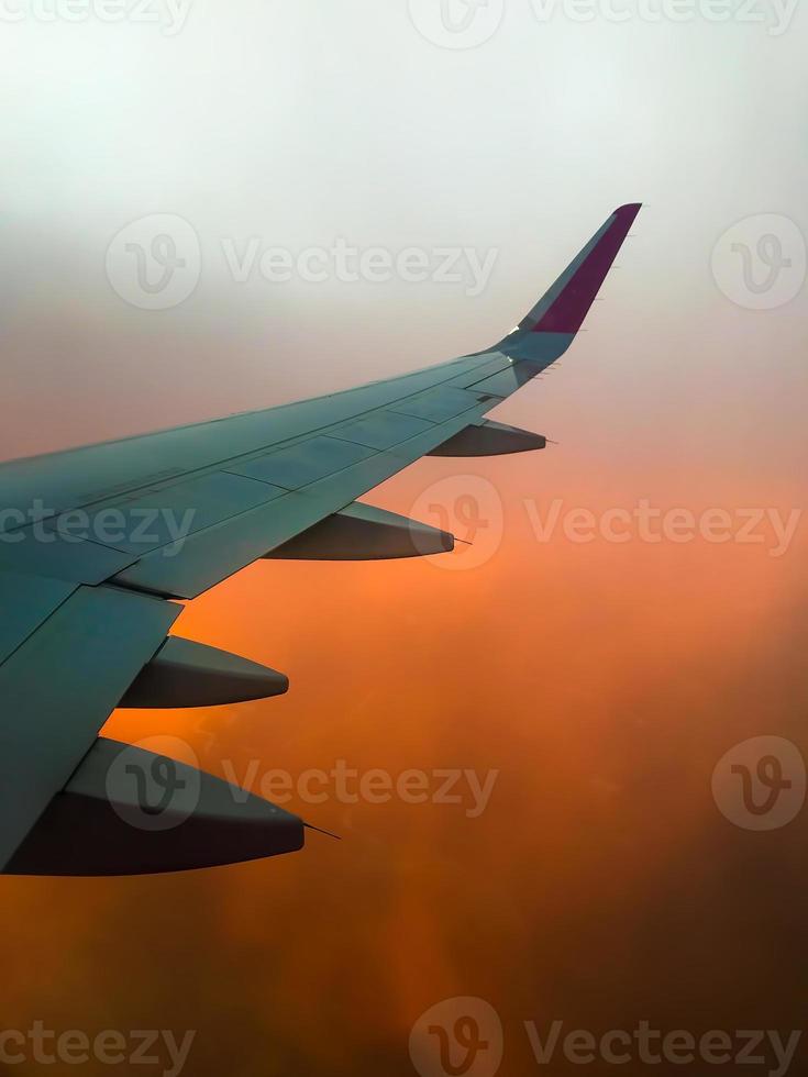 Hazy airplane wing view sunny cinematic panorama during flight over land copy paste vertical background photo