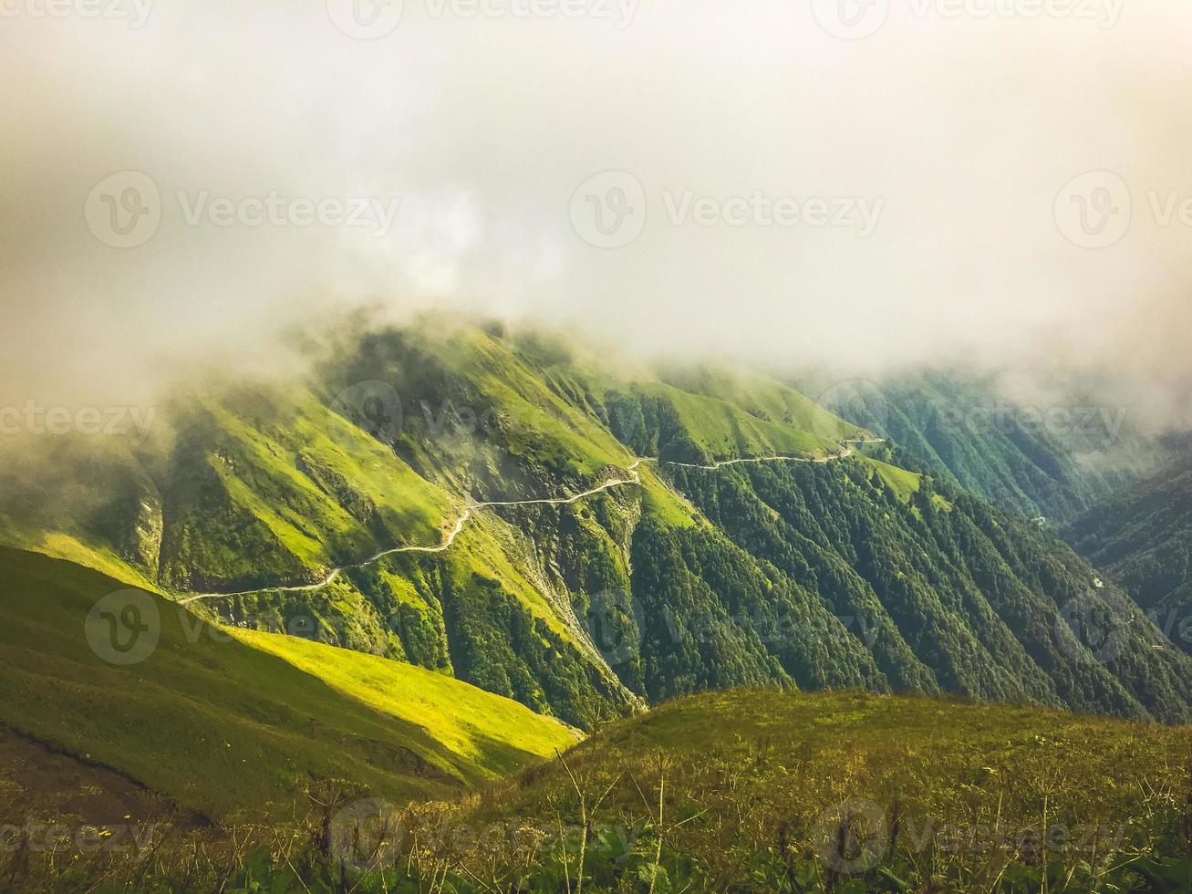 impresionante panorama cinematográfico de la carretera tusheti con niebla y paisaje verde. viajes extremos georgianos viajes de aventura foto