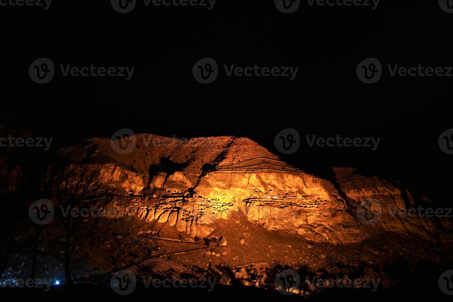 Black sky background with no stars above the famous travel sightseeing attraction in Georgia-Vardzia cave city at night. photo