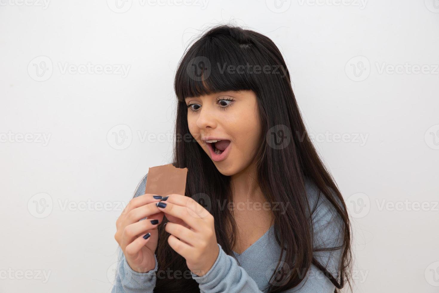 mujer joven comiendo chocolate foto