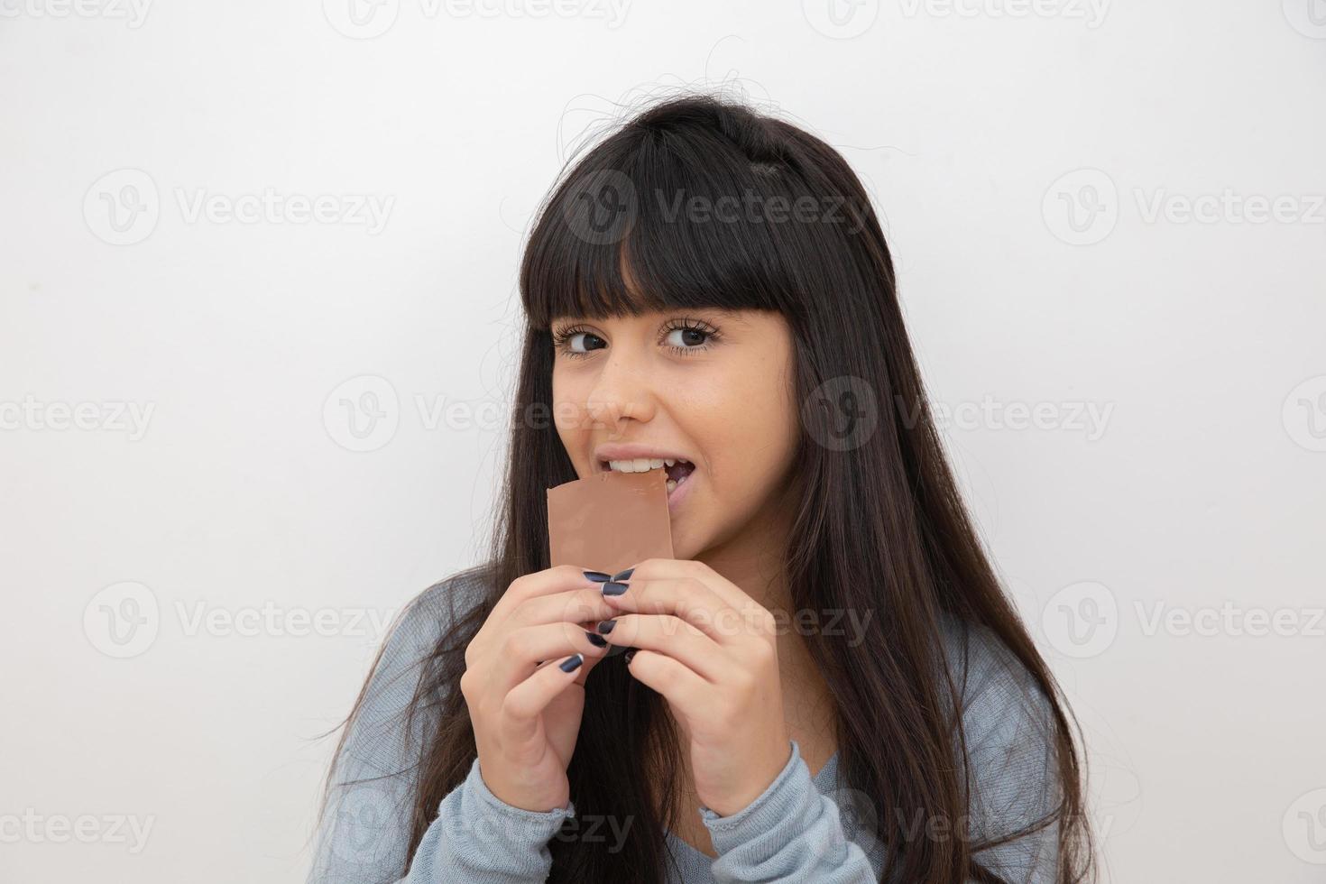 mujer joven comiendo chocolate foto