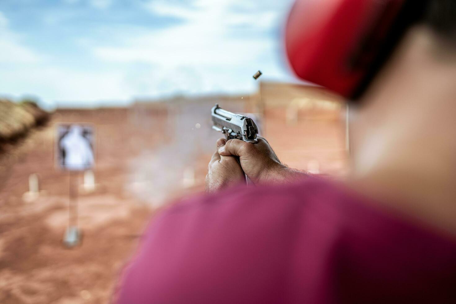 Detail view of shooter holding gun and training tactical shooting, focus on pistol. Shooting range. photo