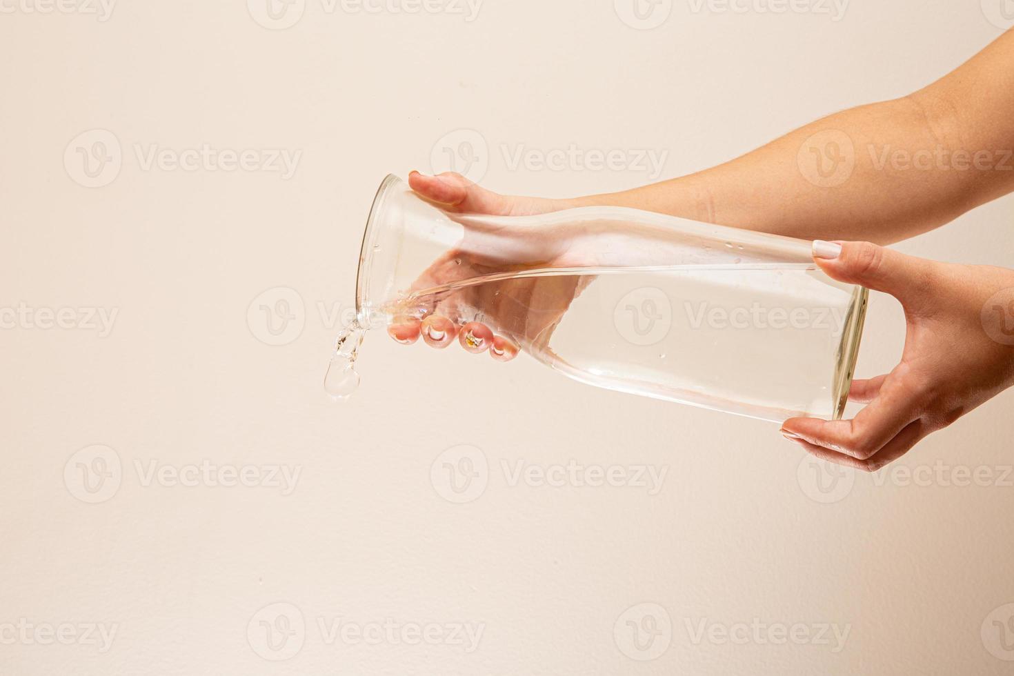 verter agua en un vaso. vertido de agua. salpicaduras de agua sobre fondo blanco. foto