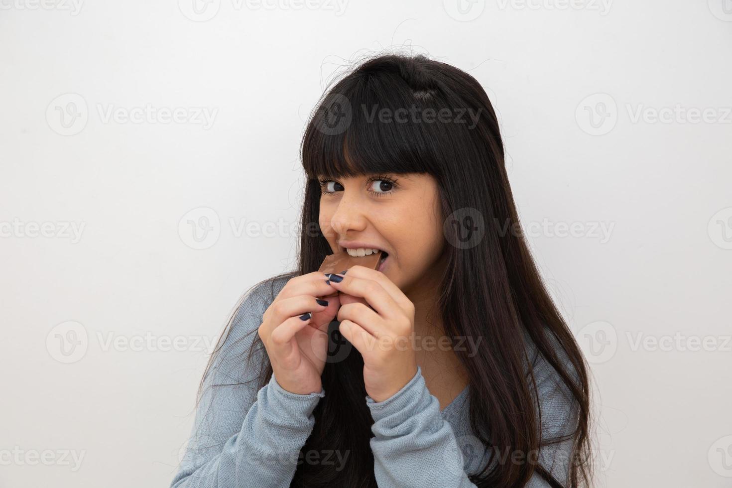 mujer joven comiendo chocolate foto