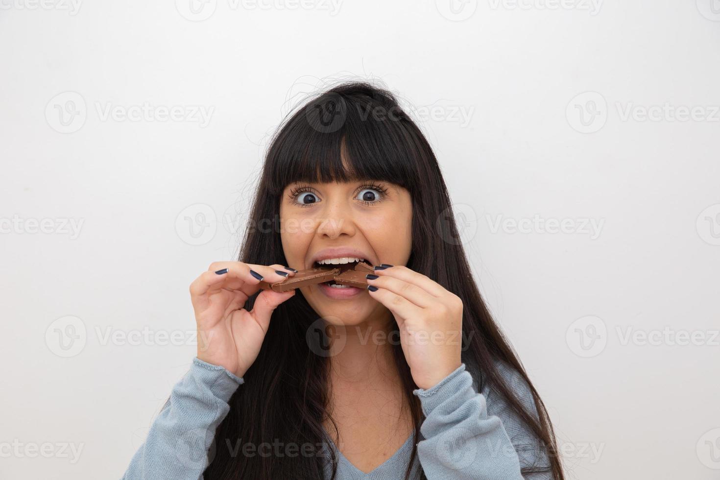 mujer joven comiendo chocolate foto