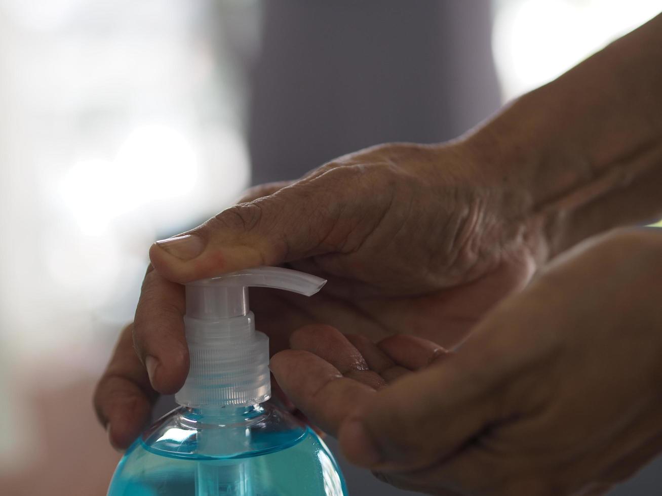 empujar gotas de gel en la mano mujer sosteniendo desinfectante de manos en gel, mezcla de gel alcohólico con gelatina en botella de plástico transparente con bomba empujando para prevenir gérmenes proteger enfermedad contagiosa corona virus, covid-19 foto