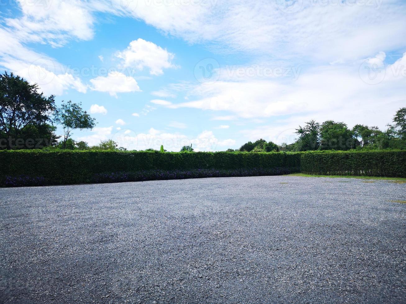 Parking lot sprinkled with gravel on tree bush nature background photo