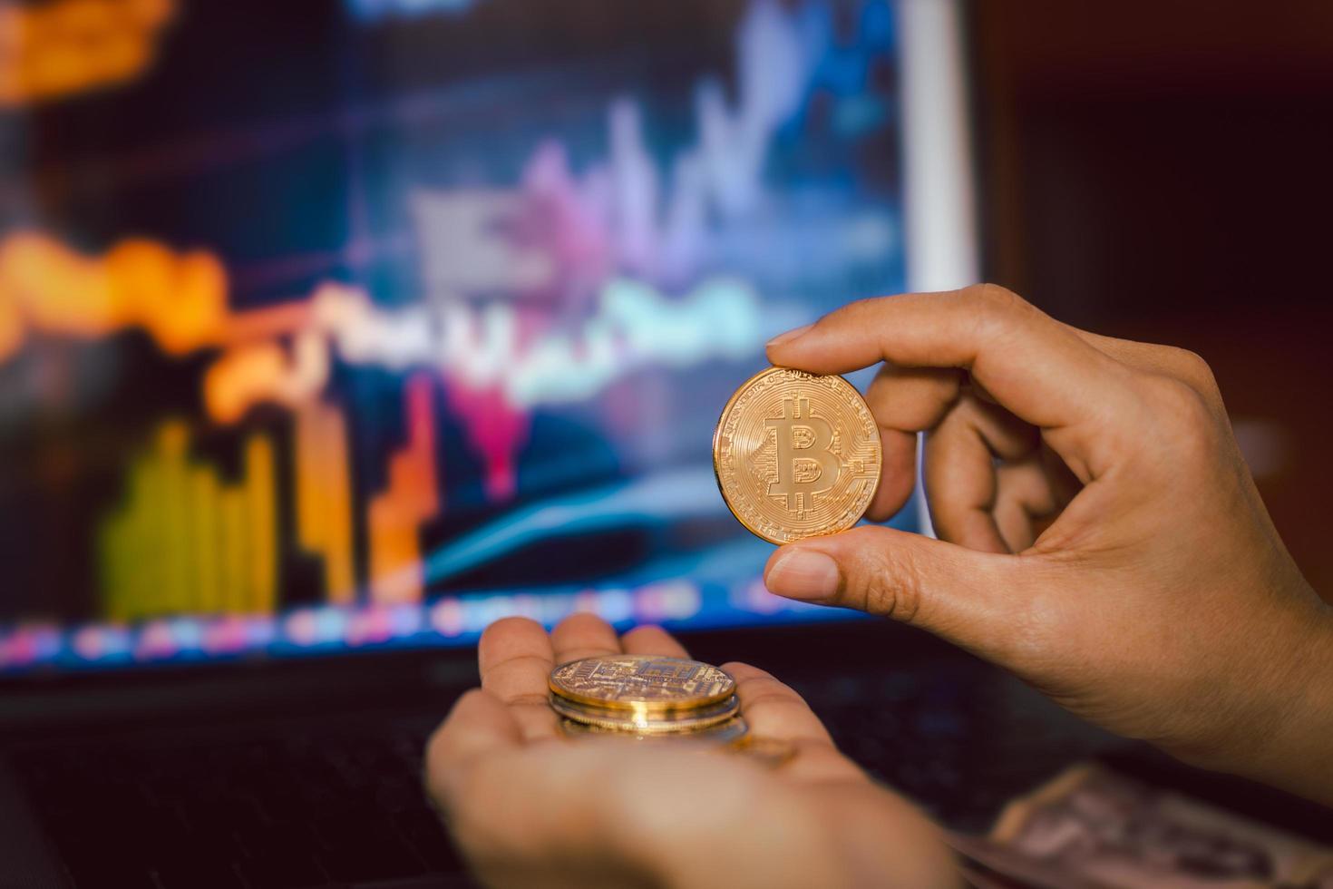 Business men holding bitcoin whit computer trading chart in background. photo