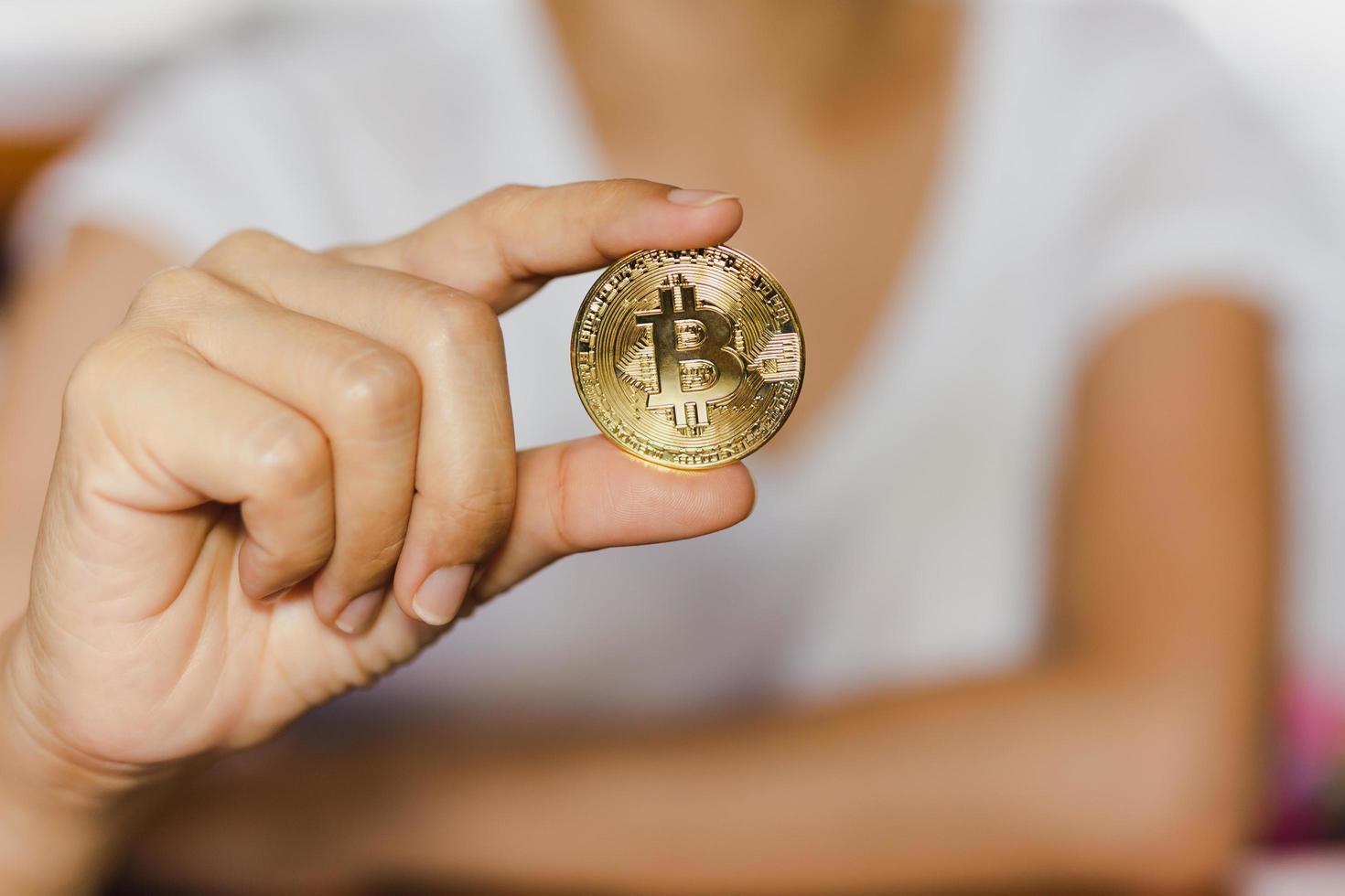 Successful woman holding gold bitcoin in her hand. photo