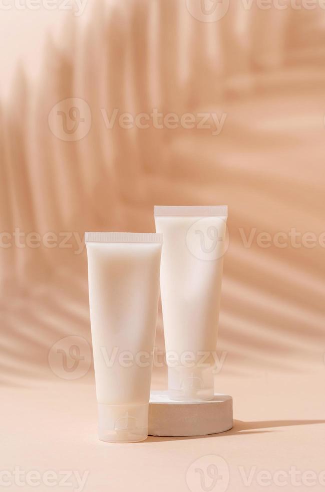 maqueta de tubo de crema para presentación de marca. producto de belleza natural para el cuidado de la piel en un podio blanco cuadrado. colores tierra naturales foto