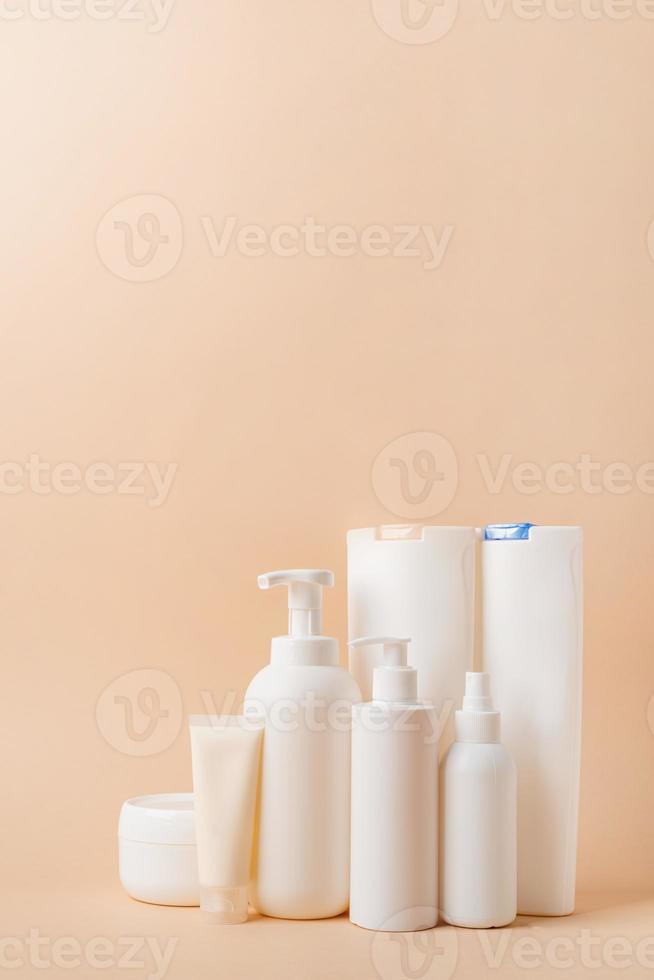 grupo de tubos de embalaje en blanco y recipientes para cosméticos sobre fondo de color natural beige, diseño de maqueta, respetuoso con el medio ambiente foto