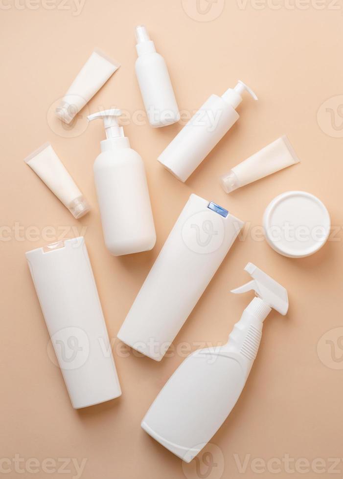 Group of white blank packaging tubes and containers for cosmetics on beige natural color background, mockup design, eco friendly photo