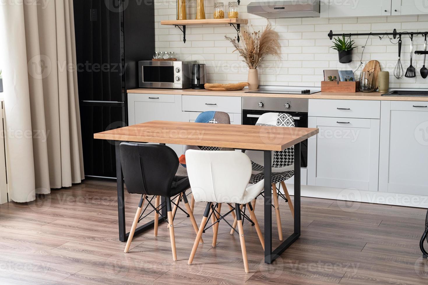 interior de cocina de estilo rústico con utensilios de cocina antiguos y paredes de madera. muebles blancos y decoración de madera en una cabaña luminosa interior. foto