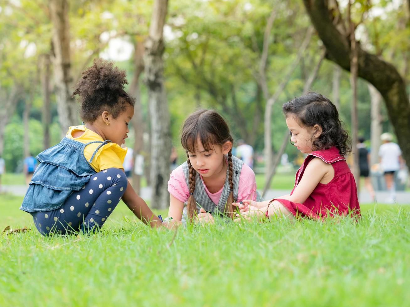 un grupo de niños pequeños de muchas nacionalidades juegan y aprenden fuera de la escuela foto