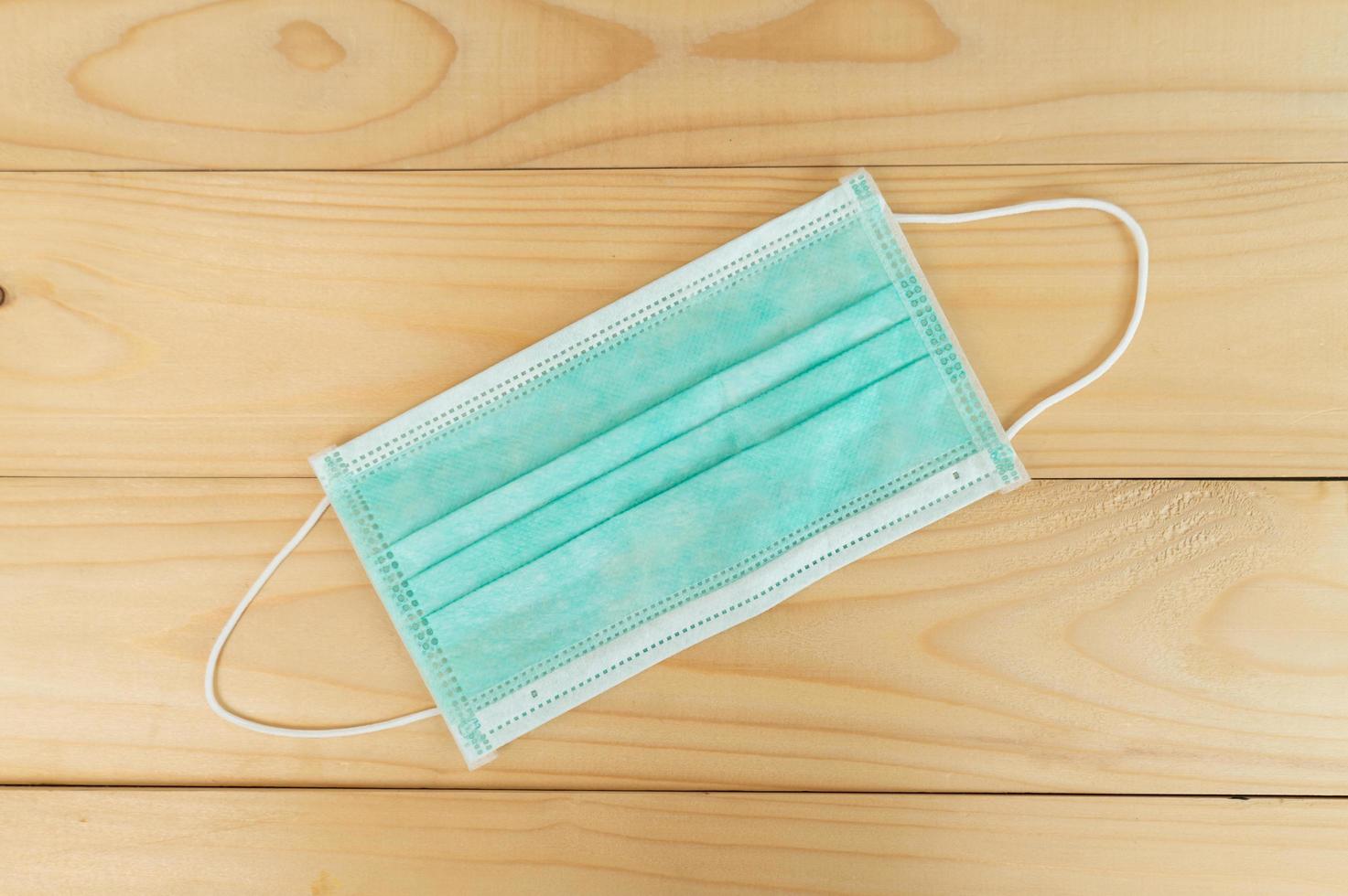 mascarilla quirúrgica con correas de goma para los oídos sobre fondo de madera.concepto de protección. foto