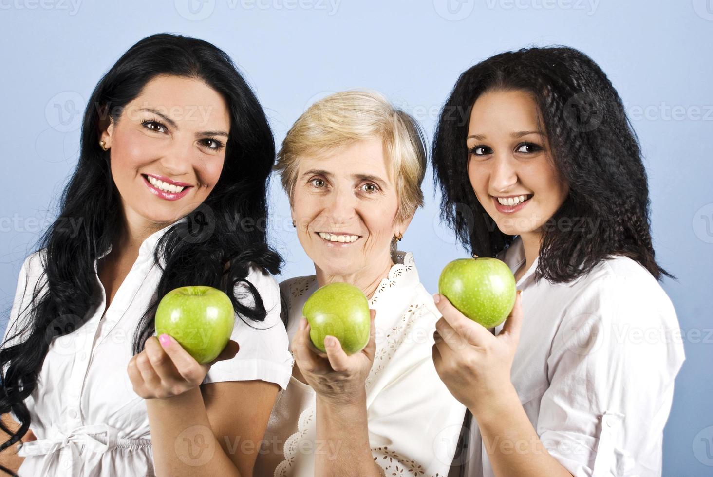 Three healthy beauty women giving you apples photo