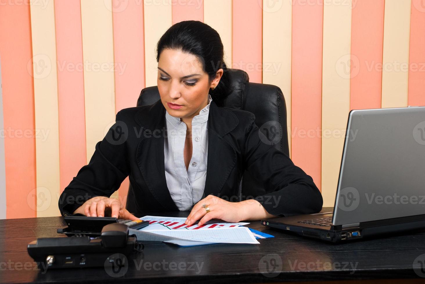 Corporate  woman using calculator photo