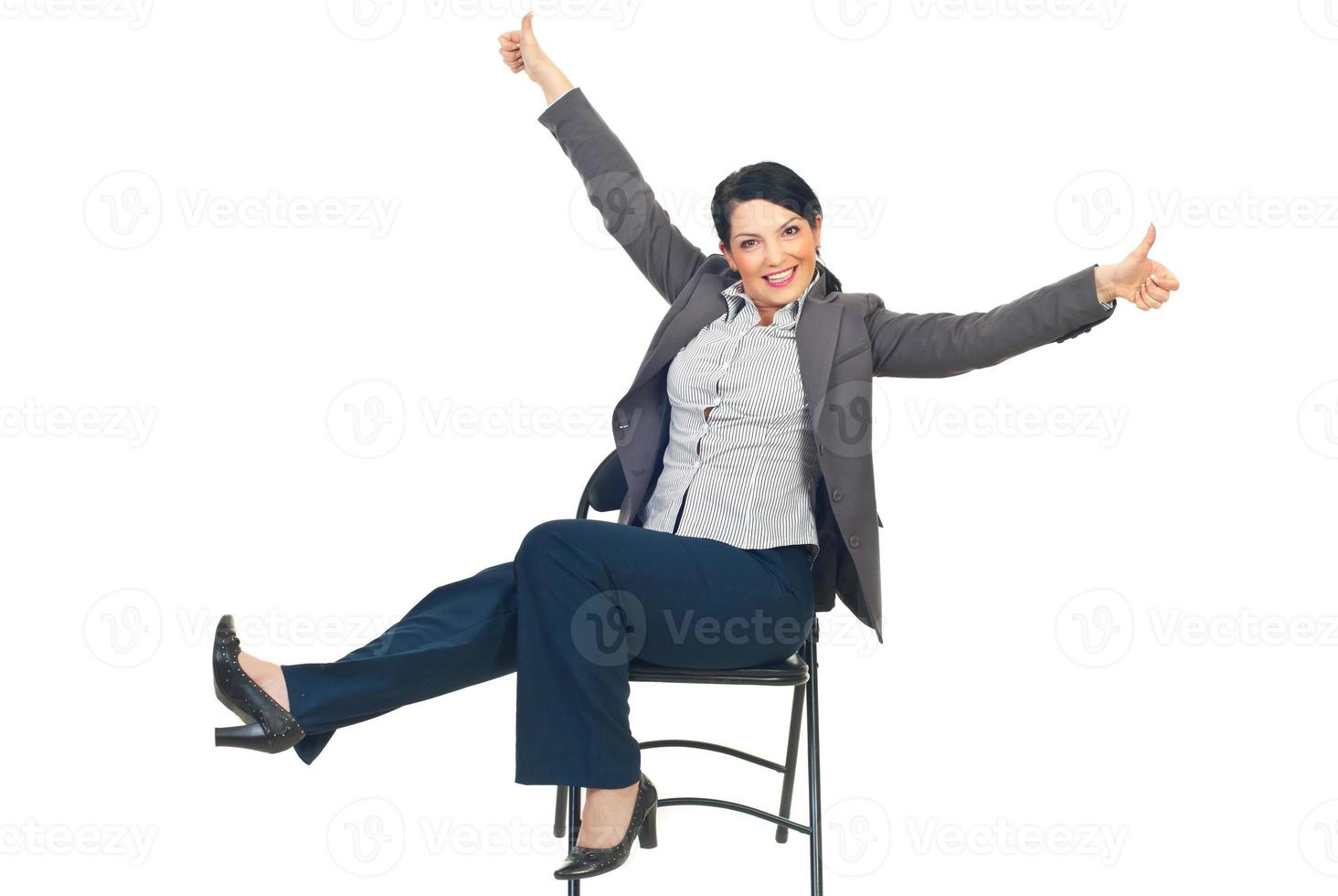 Successful businesswoman on chair gives thumbs photo