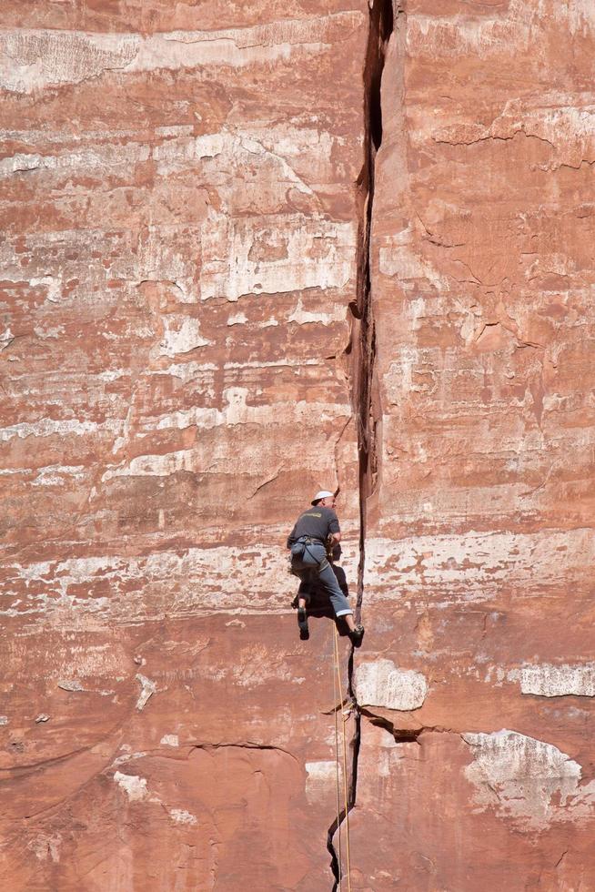 zion, utah, estados unidos de 2009. hombre escalando una pared rocosa en el parque nacional de zion foto