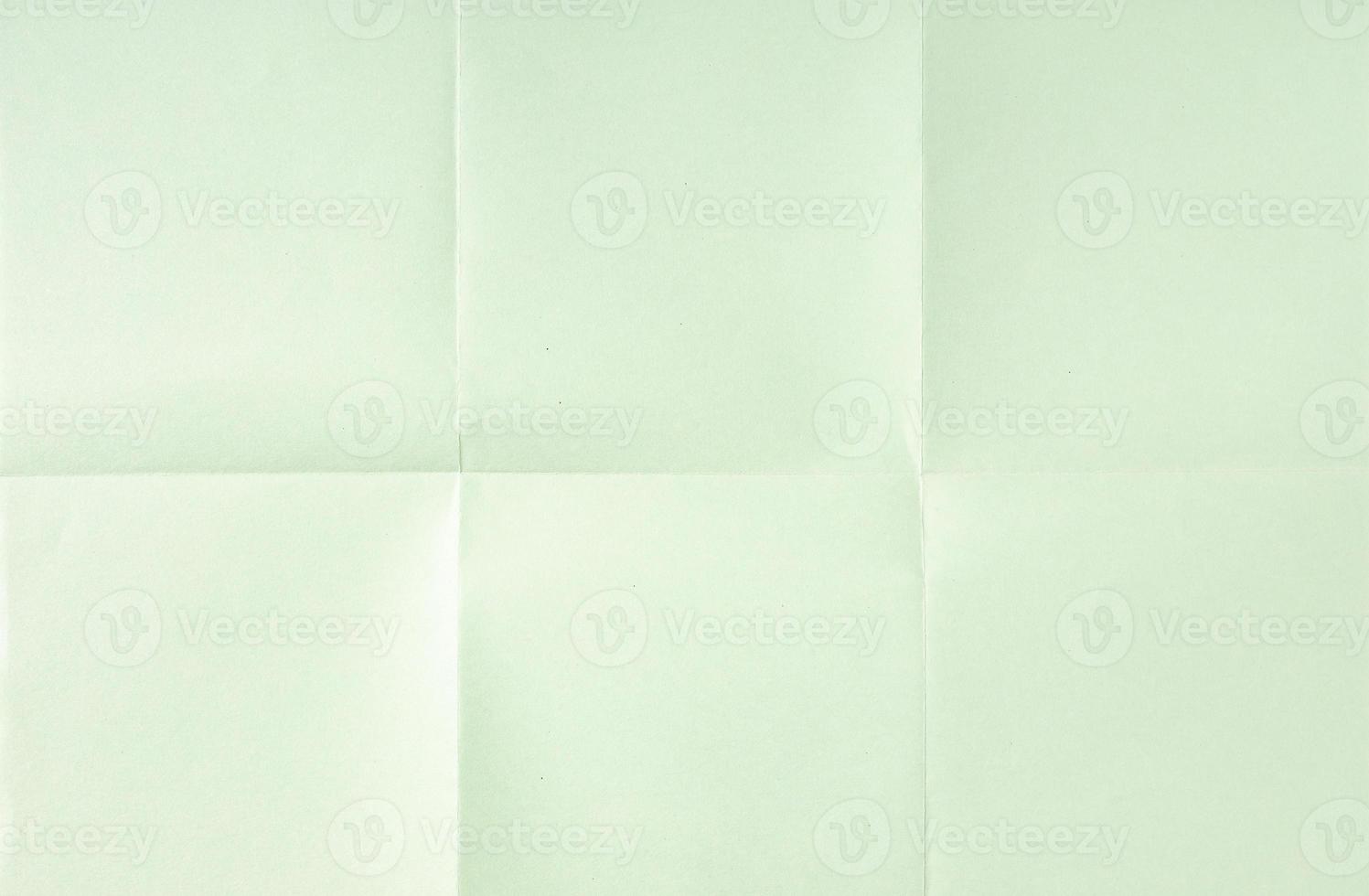 Light green crumpled unfolded paper sheet texture background. Paper folded in six. Full frame photo