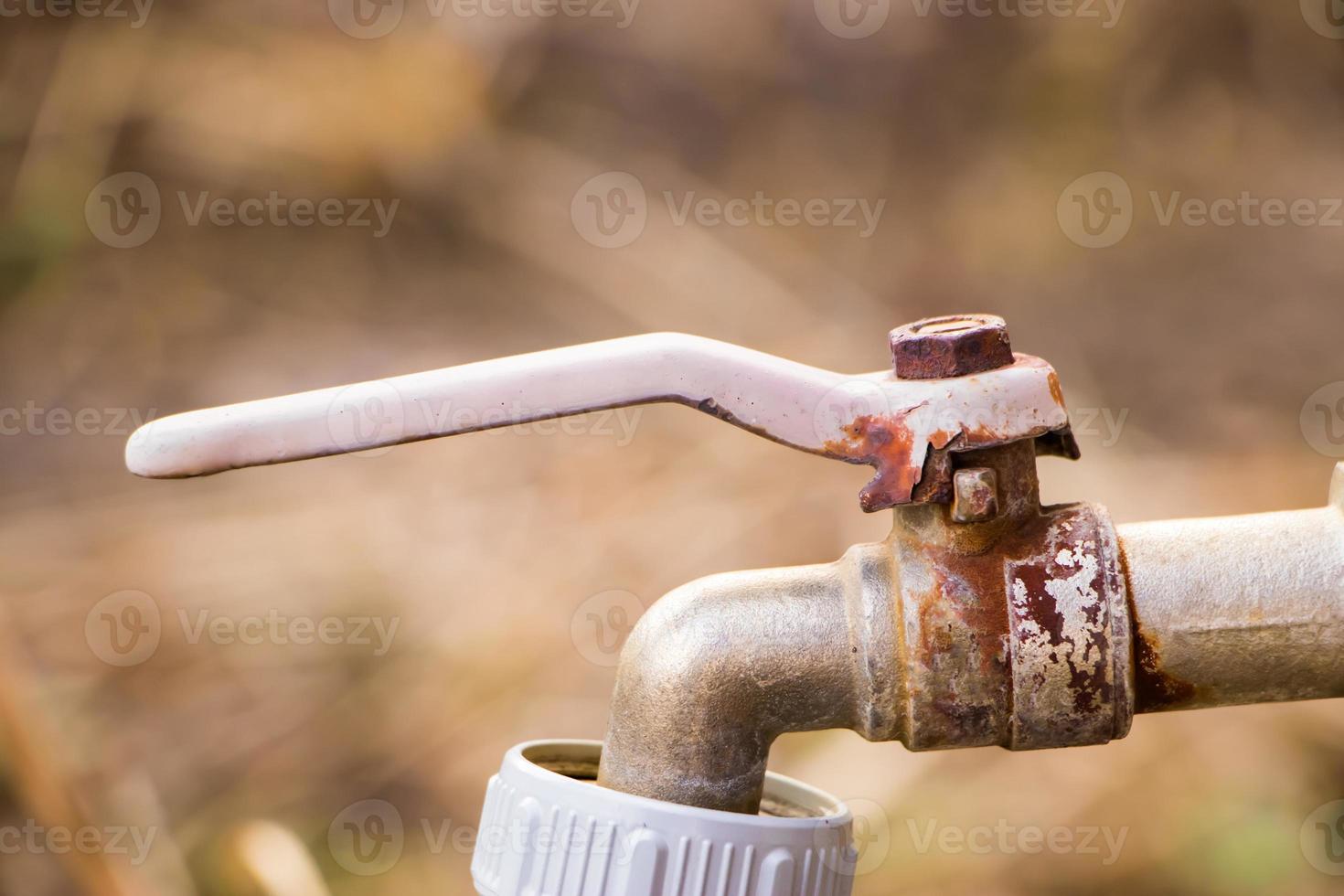 viejo grifo de agua oxidado. dispositivo abandonado para regar plantas en un invernadero. foto