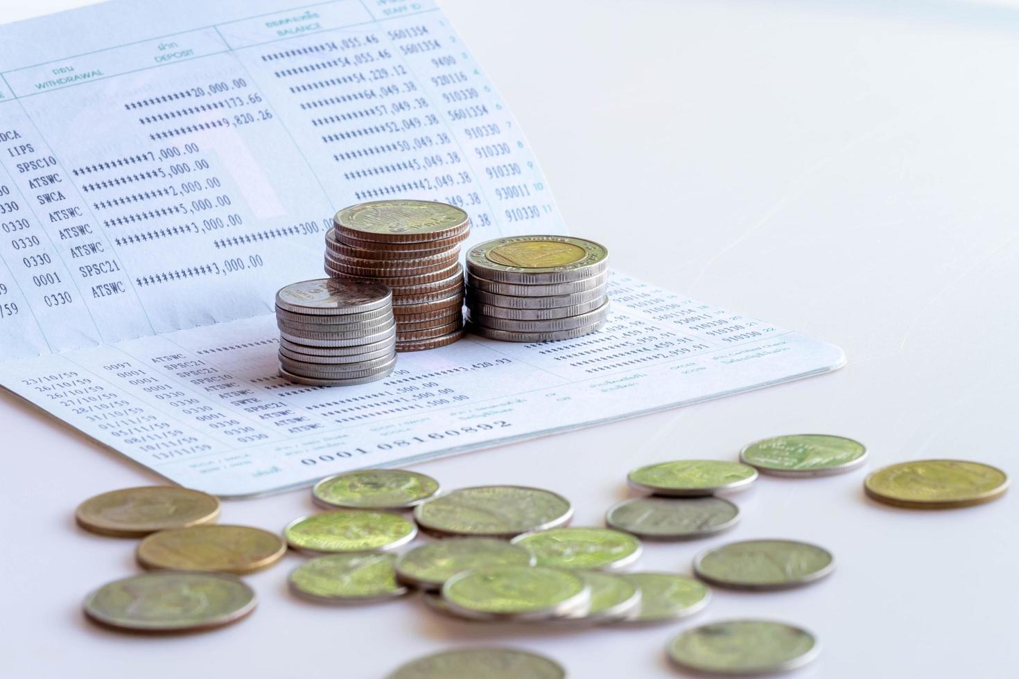 Book bank saving deposit account isolated on white background. Saving account bookbank statement and thai currency coins. Financial bookkeeping, Accountancy Concept. photo