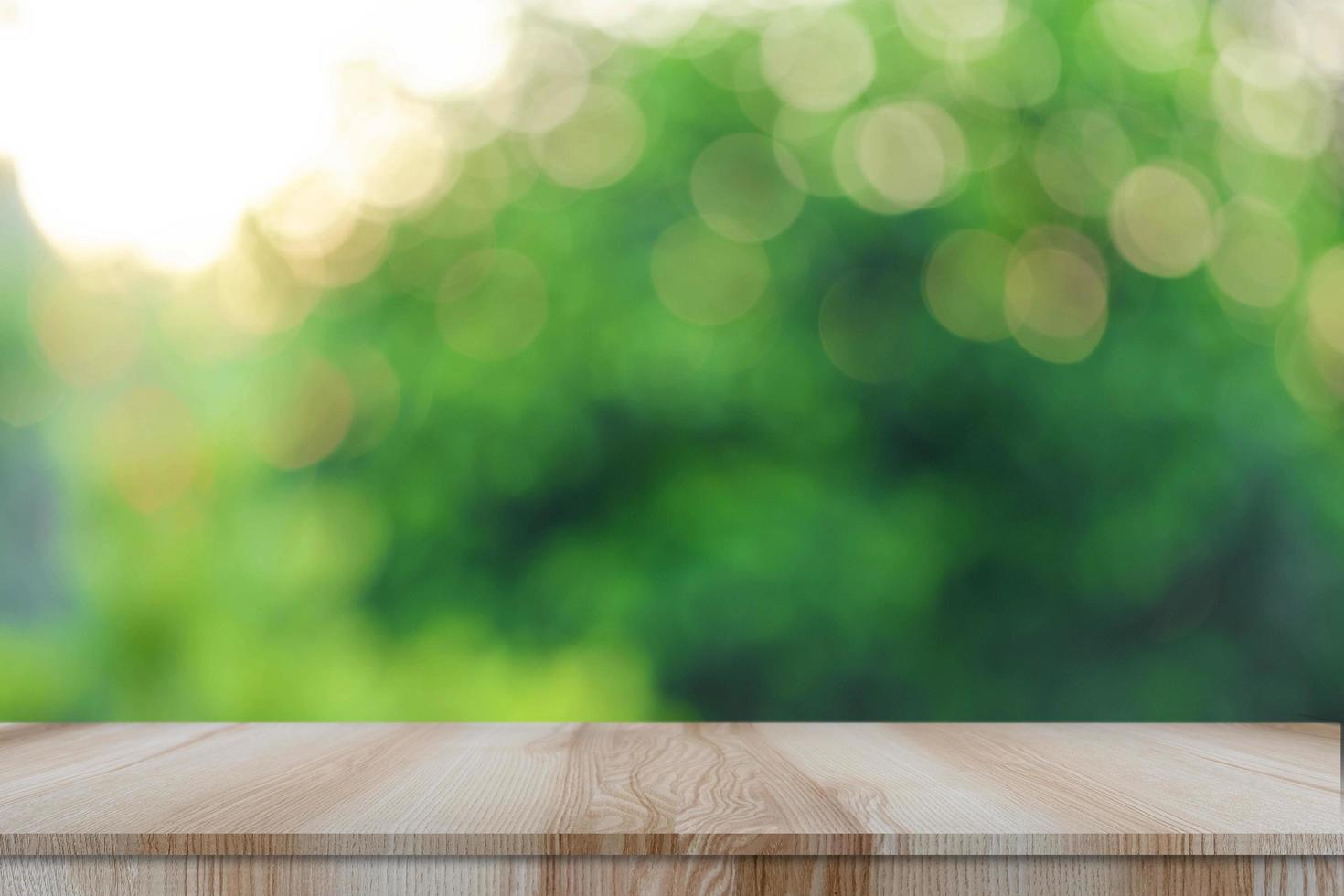 Empty modern brown wooden table with bokeh green nature background photo