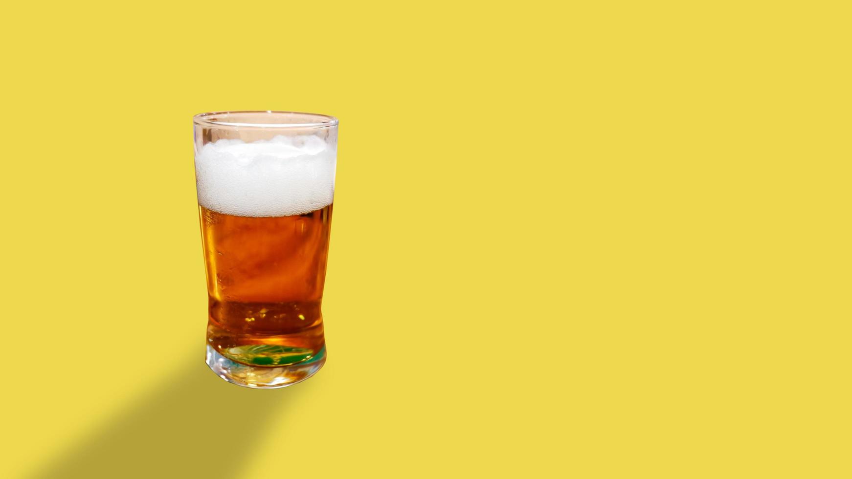 Beer glass on a yellow background. photo
