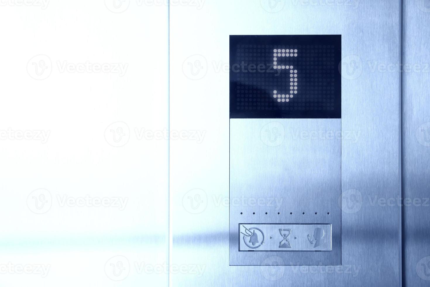 Electronic display inside elevator informs five floor photo