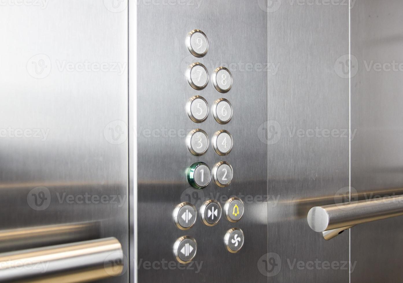 Buttons and handrail in metal elevator photo