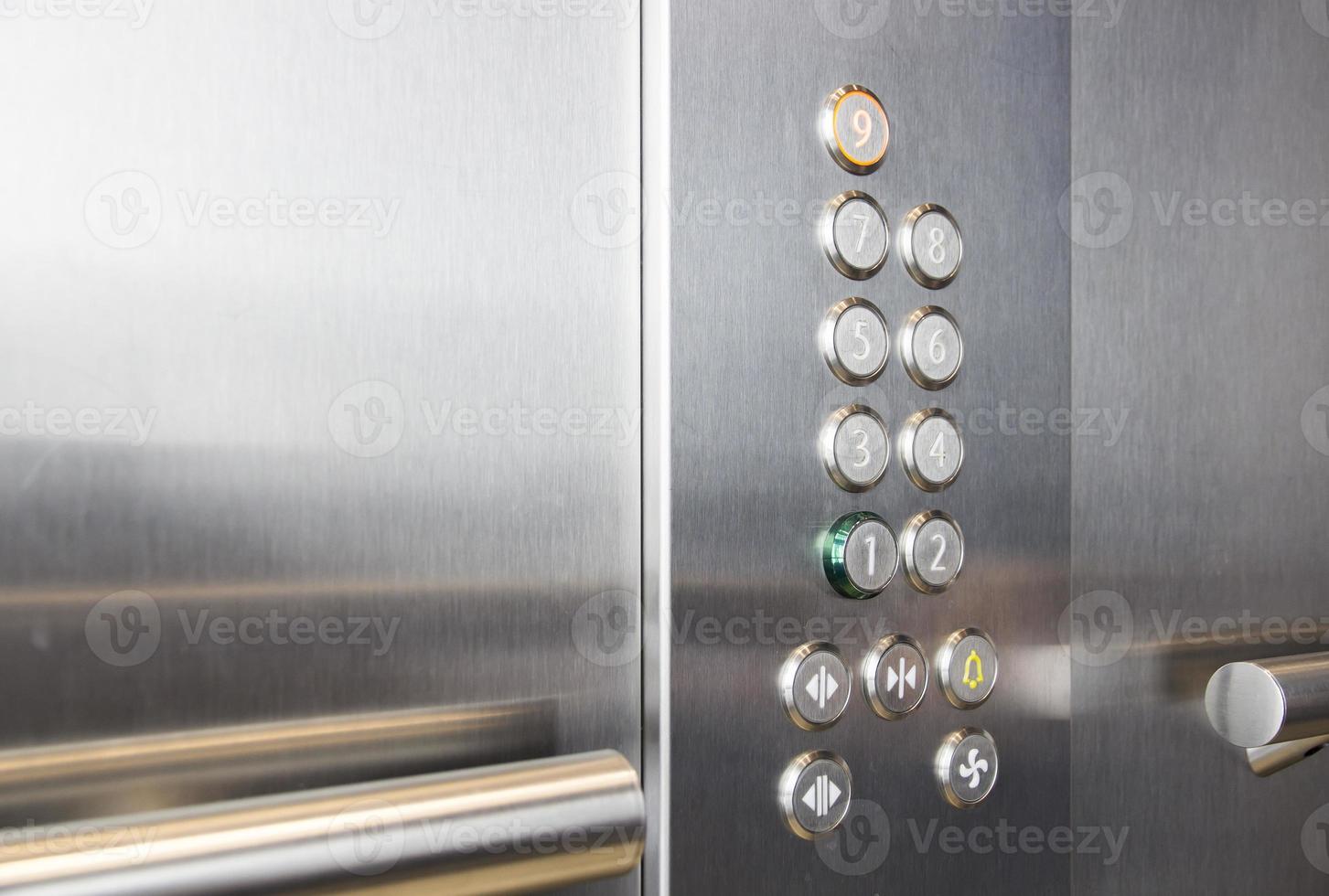 Buttons and handrail in metal elevator photo