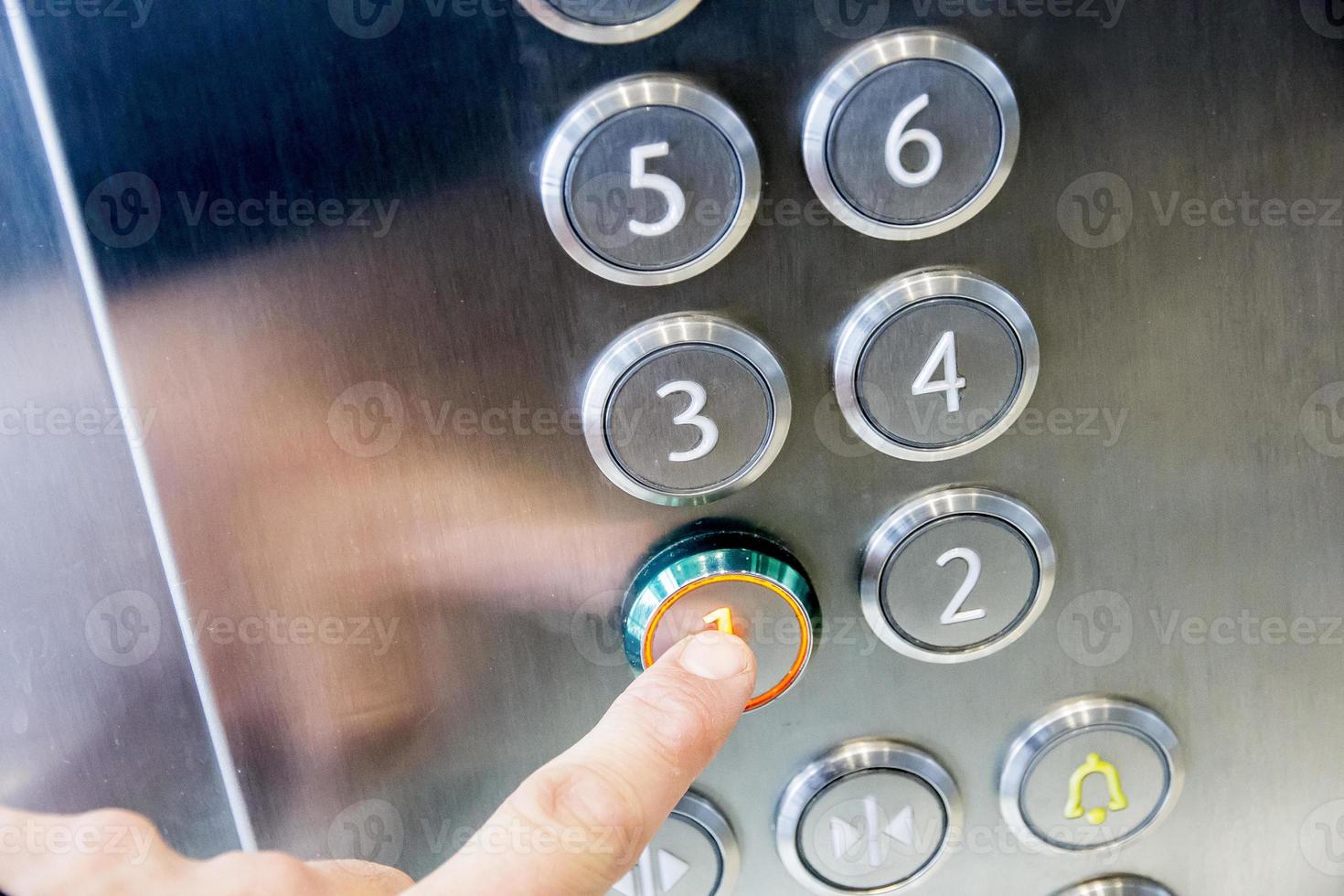 Man's hand causes first floor in metal elevator photo