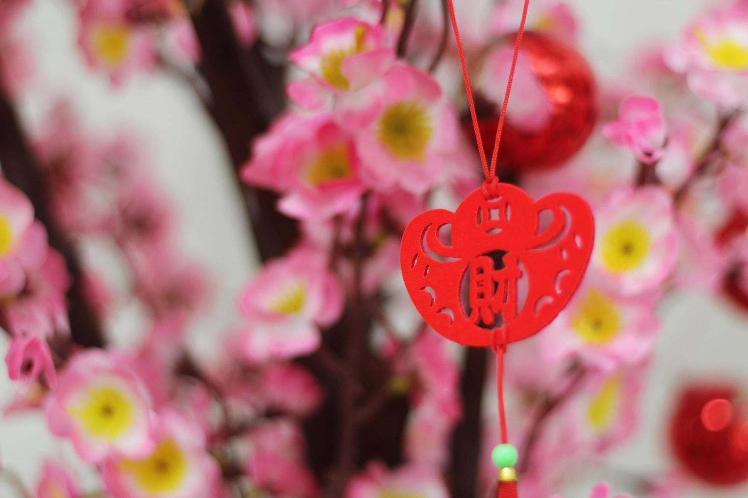 Pink Cherry Blossoms with Chinese ornaments on a blur cafe background photo