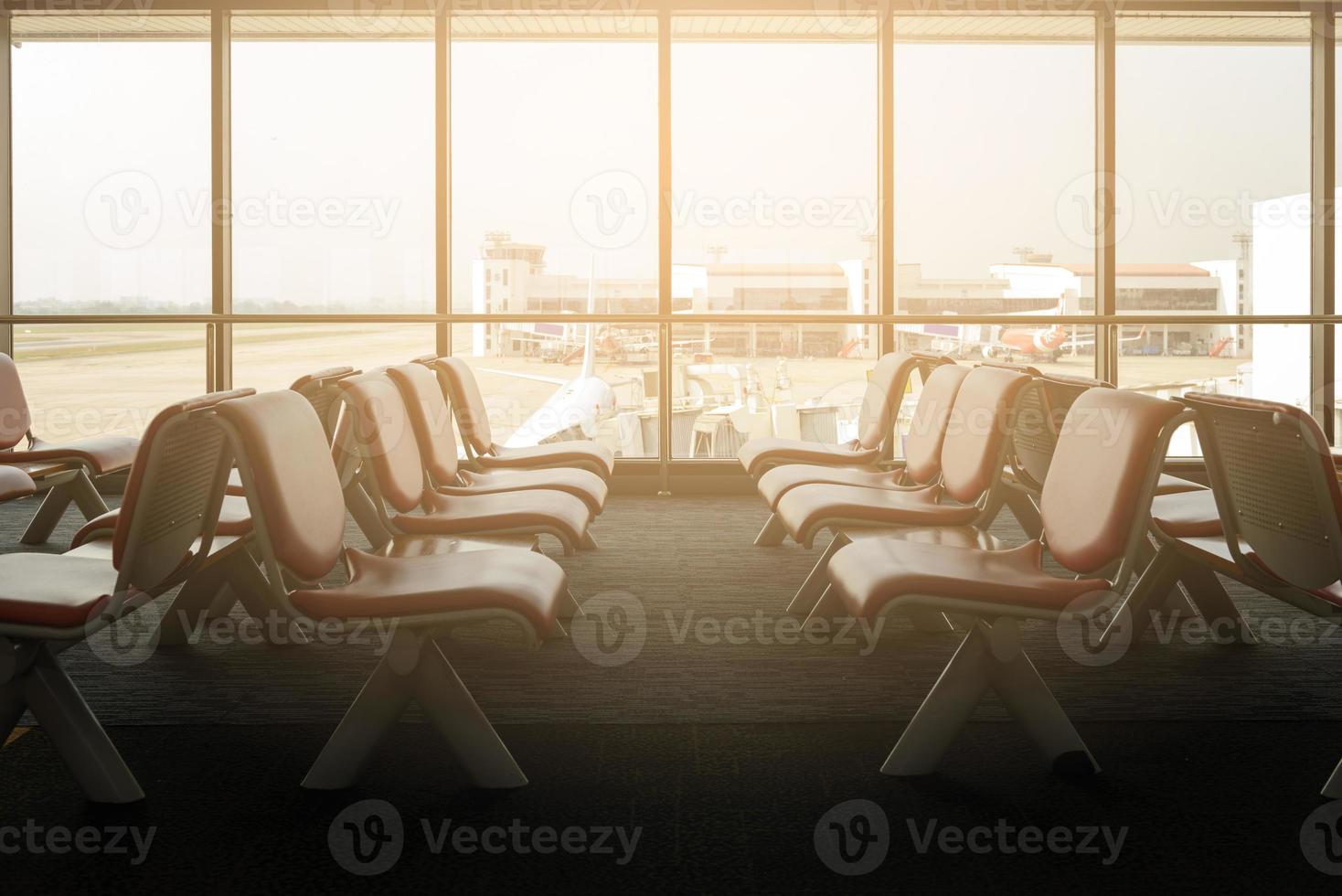 Departure lounge with empty chairs in the terminal of airport, waiting area photo