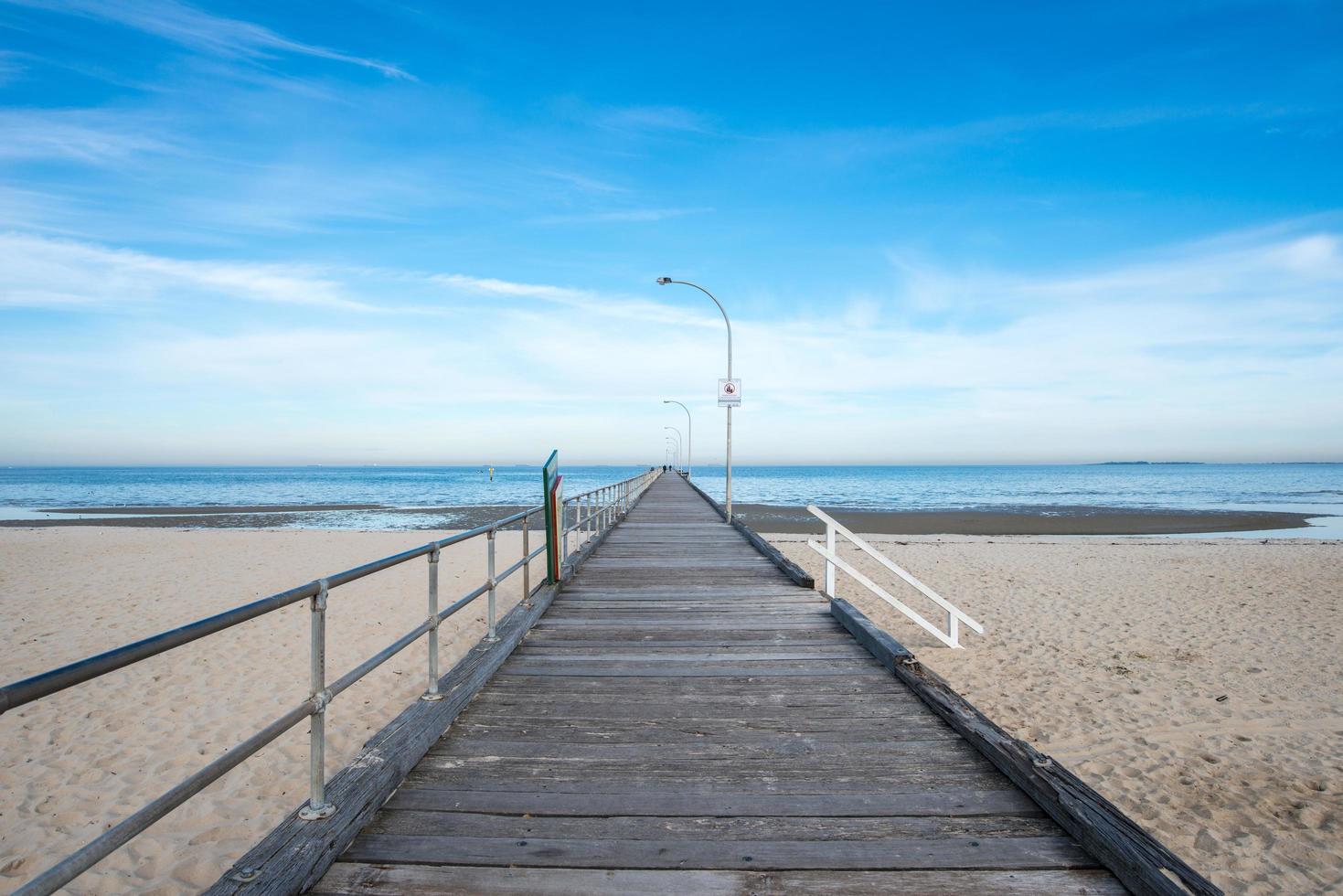 el paseo marítimo de madera y la vista del paisaje de la playa de altona, cerca de la ciudad de melbourne, australia. foto