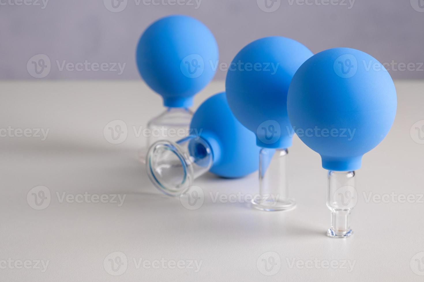 Vacuum pot for vacuum facial massage stands on a wooden table photo