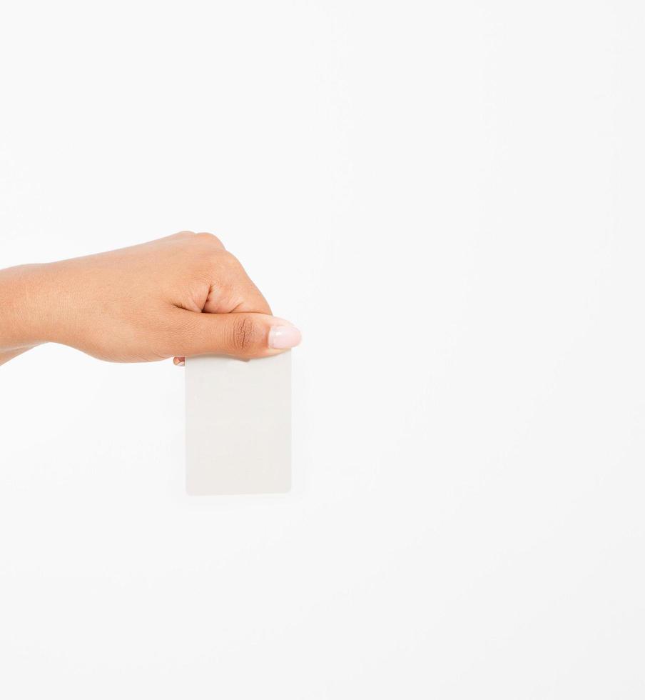 hand hold blank business card. female arm hold paper isolated on white background. copy space. mock up. photo