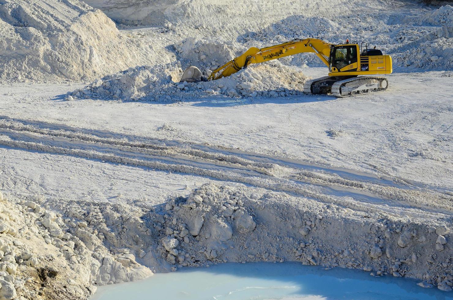 excavadora amarilla en cantera de piedra caliza foto